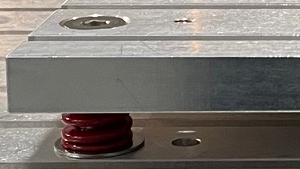 Figure 1. Fixture used for BGA underfill milling showing adjustable spring load mount points on fixture corners.