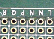 Figure 2: Conductor was soldered to row of plated holes and buried below the circuit board surface by running within a machined groove.